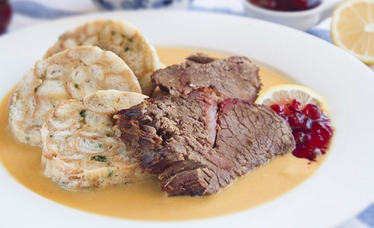 Svíčková con knedliky, piatto tipico ceco a base di stufato di manzo, gnocchi di pane, salsa alla panna e marmellata portata principale tradizionale repubblica ceca svickova e knedliky panna acida frutti rossi