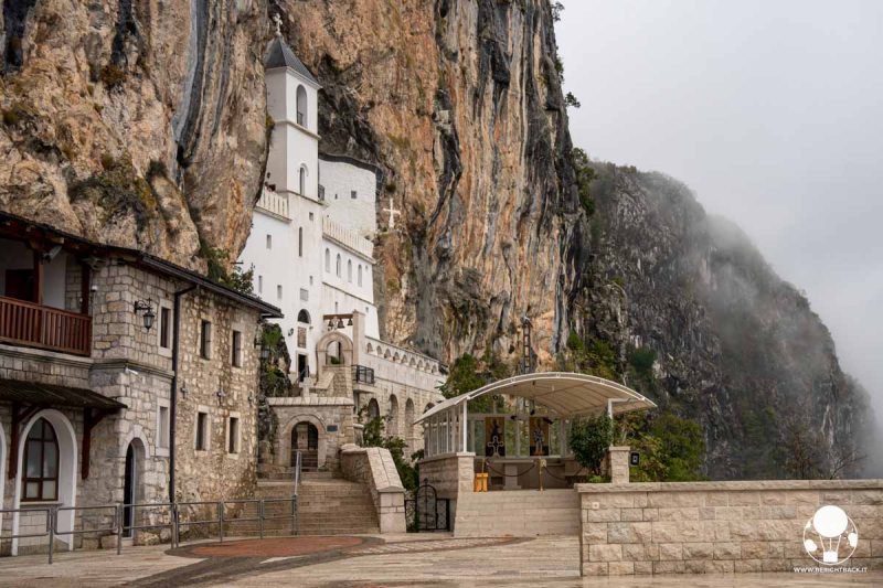 monastero scavato nella roccia in mezzo alla nebbia