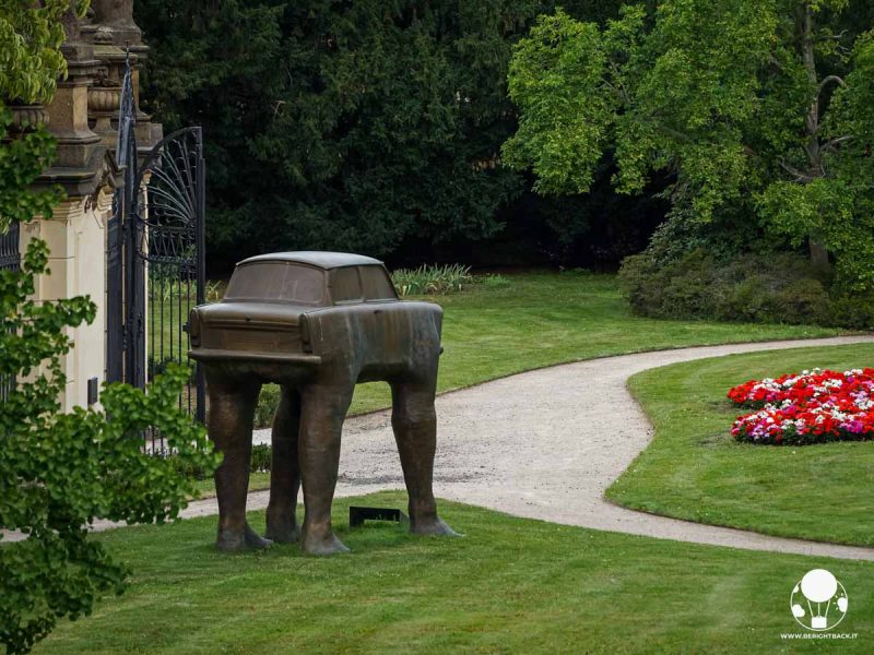 auto con quattro gambe umane all'interno di un giardino