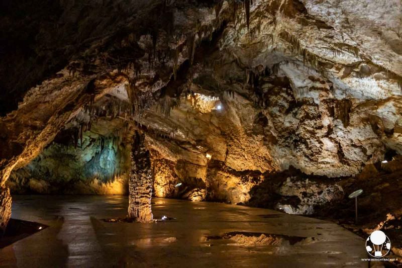 sala sotterranea illuminata con stalagmite al centro